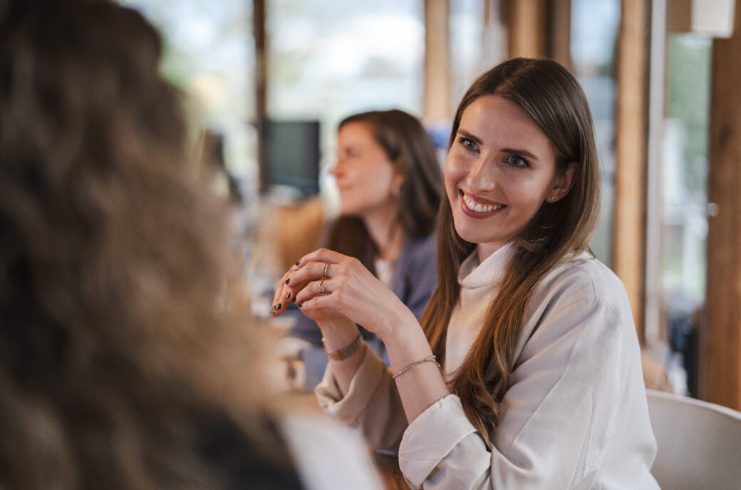 Lachende Frau bei Framechangers™-Meeting, Fokus auf emotionale Intelligenz in der Führung.