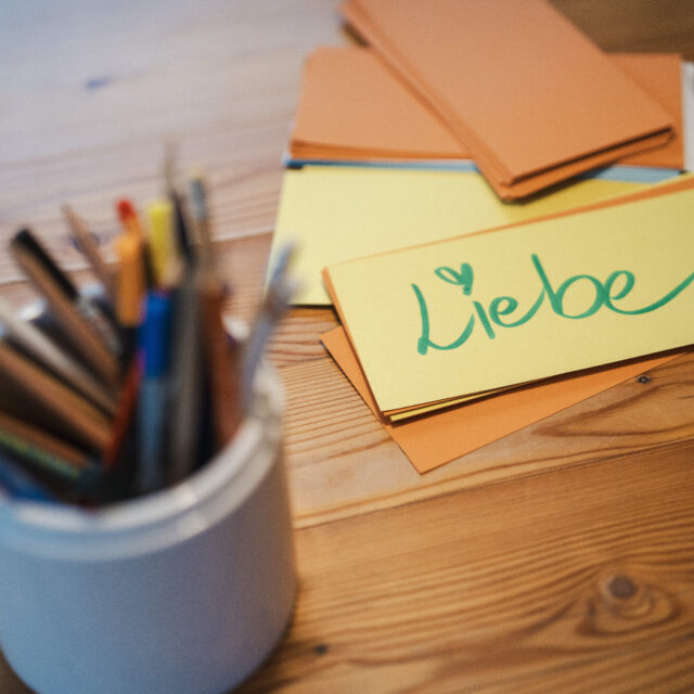 Schreibtisch mit Stiften, Notizen und dem Wort "Liebe"