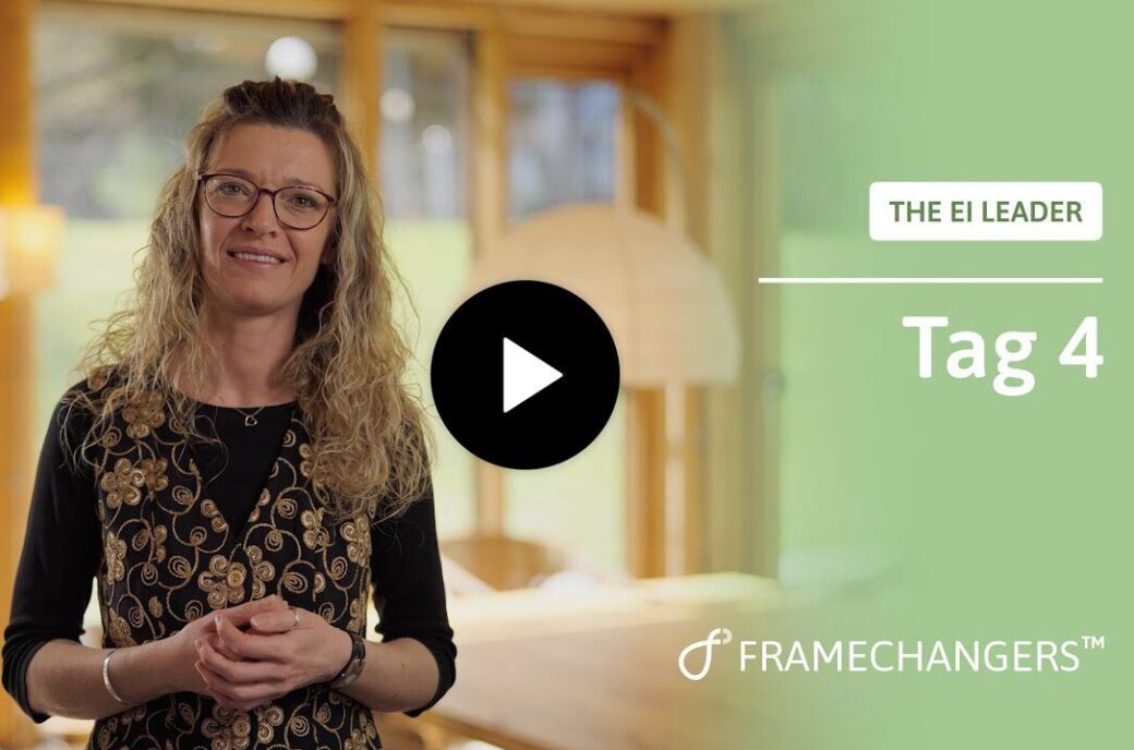 Frau mit Brille und floraler Weste lächelt vor "THE EI LEADER Tag 4" für Empathie und emotionale Resonanz.