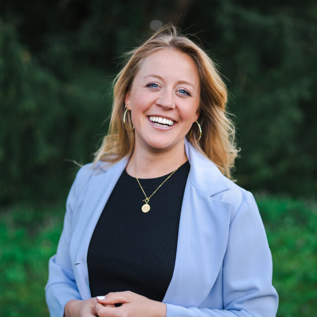 Mindful-Leadership-Coach Bianca lächelt mit Sinn und Begeisterung in die Kamera.