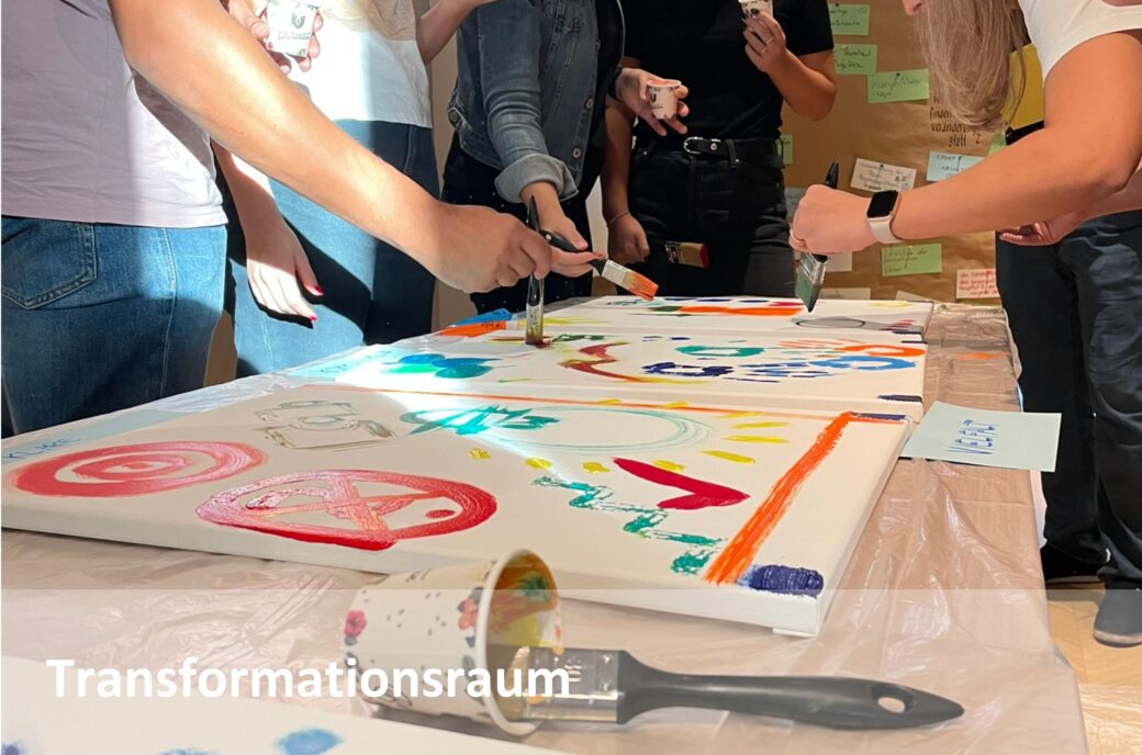 Personen malen gemeinsam ein buntes Gemeinschaftsbild.
