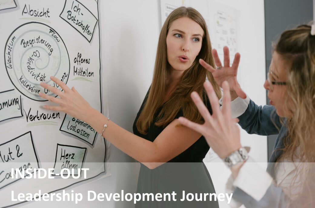 Zwei Frauen diskutieren über ein Flipchart; Text "Inside-Out Leadership Development Journey"