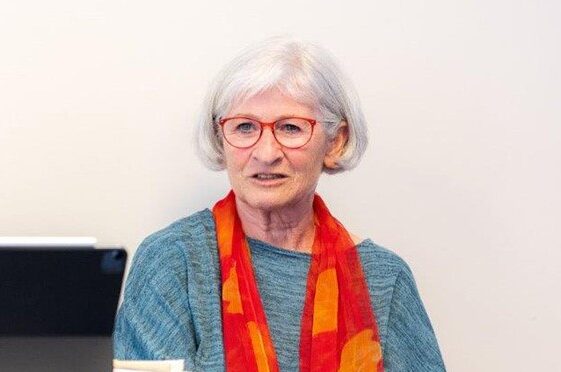 Ruth Seliger sitzend vor einer weißen Wand
