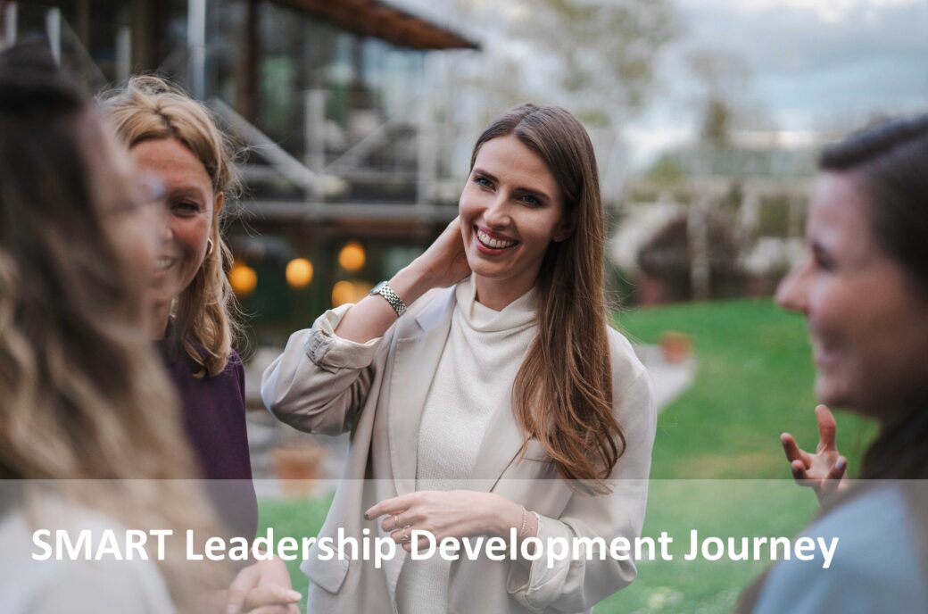 Frauen, die sich im Freien unterhalten; Text "SMART Leadership Development Journey".