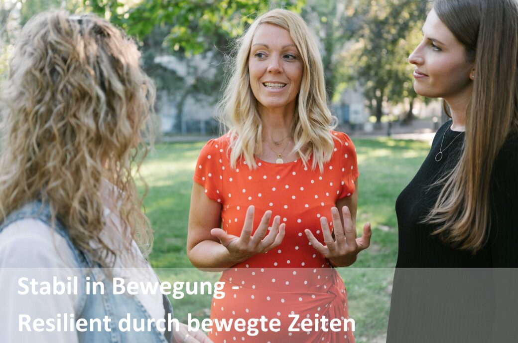 Drei Frauen im Freien diskutieren, Text "Stabil in Bewegung - Resilient durch bewegte Zeiten"